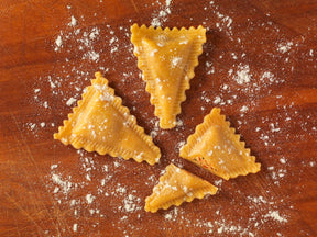Frische gefüllte Triangoli auf Brett angerichtet